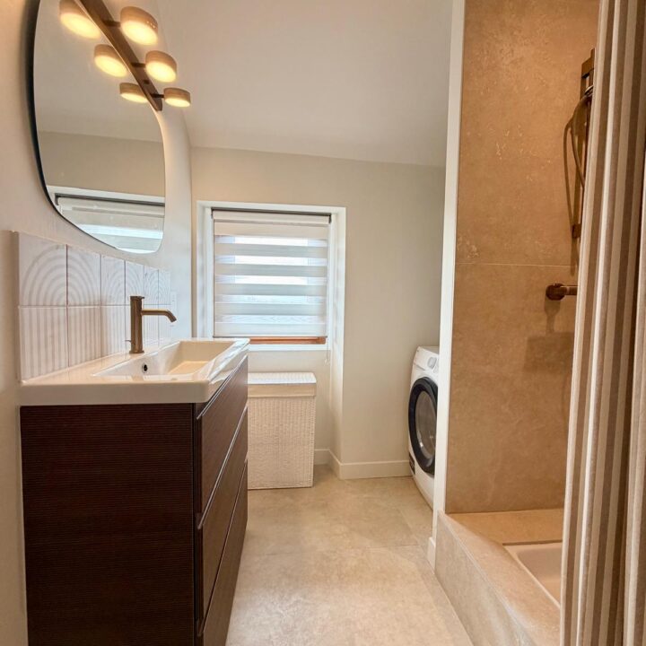 Salle de bain contemporaine avec meuble vasque en bois foncé et espace douche beige.