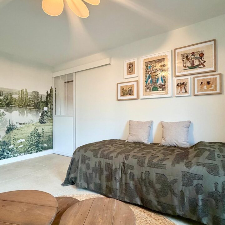 Chambre aux tons naturels avec papier peint panoramique paysager et décoration murale.